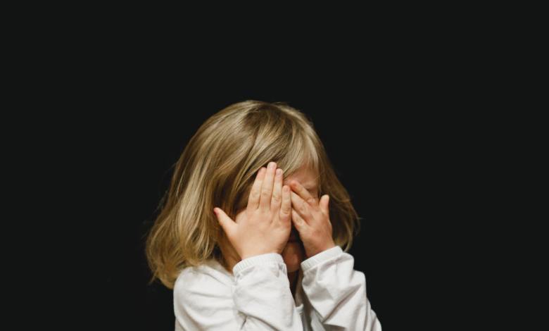 girl covering her face with both hands