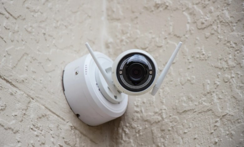 white surveillance camera hanging on wall