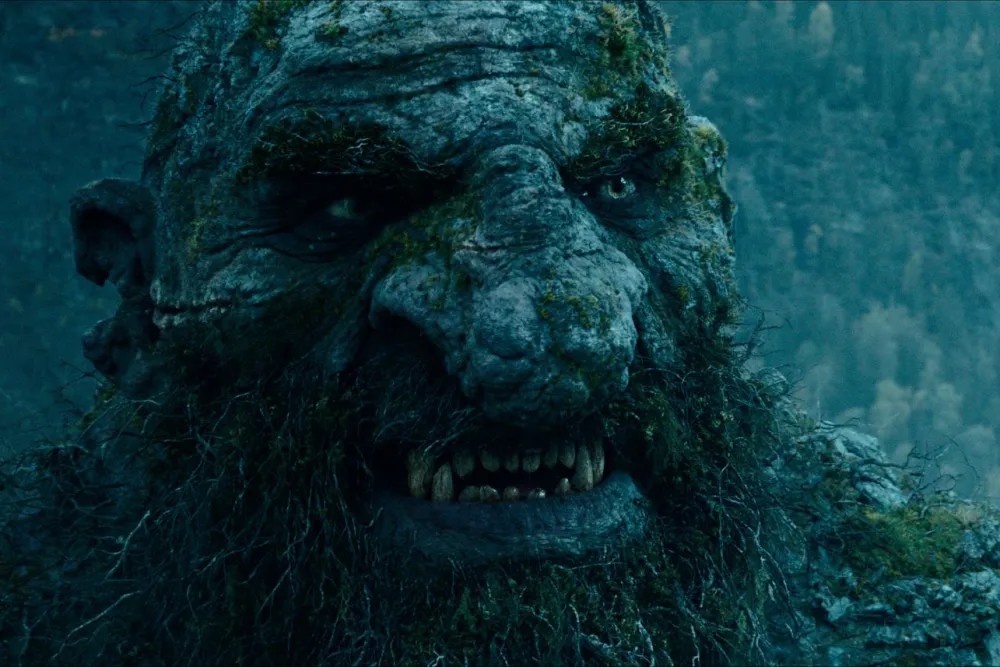Close-up of the giant stone troll face with moss details from the Troll 2 movie (2025), showcasing high-quality VFX creature design.