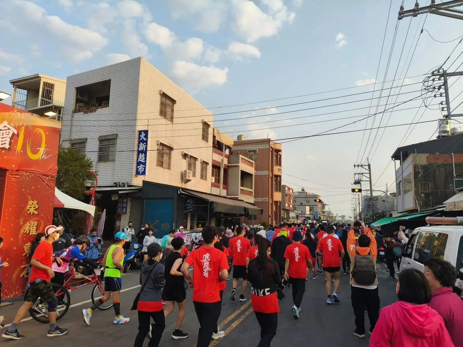 跑者在東石馬拉松賽道奔跑，工作人員嚴格巡視品質。