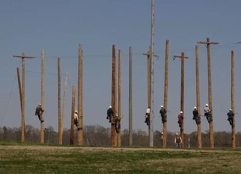 Pre-apprentice lineman class climbing telephone poles