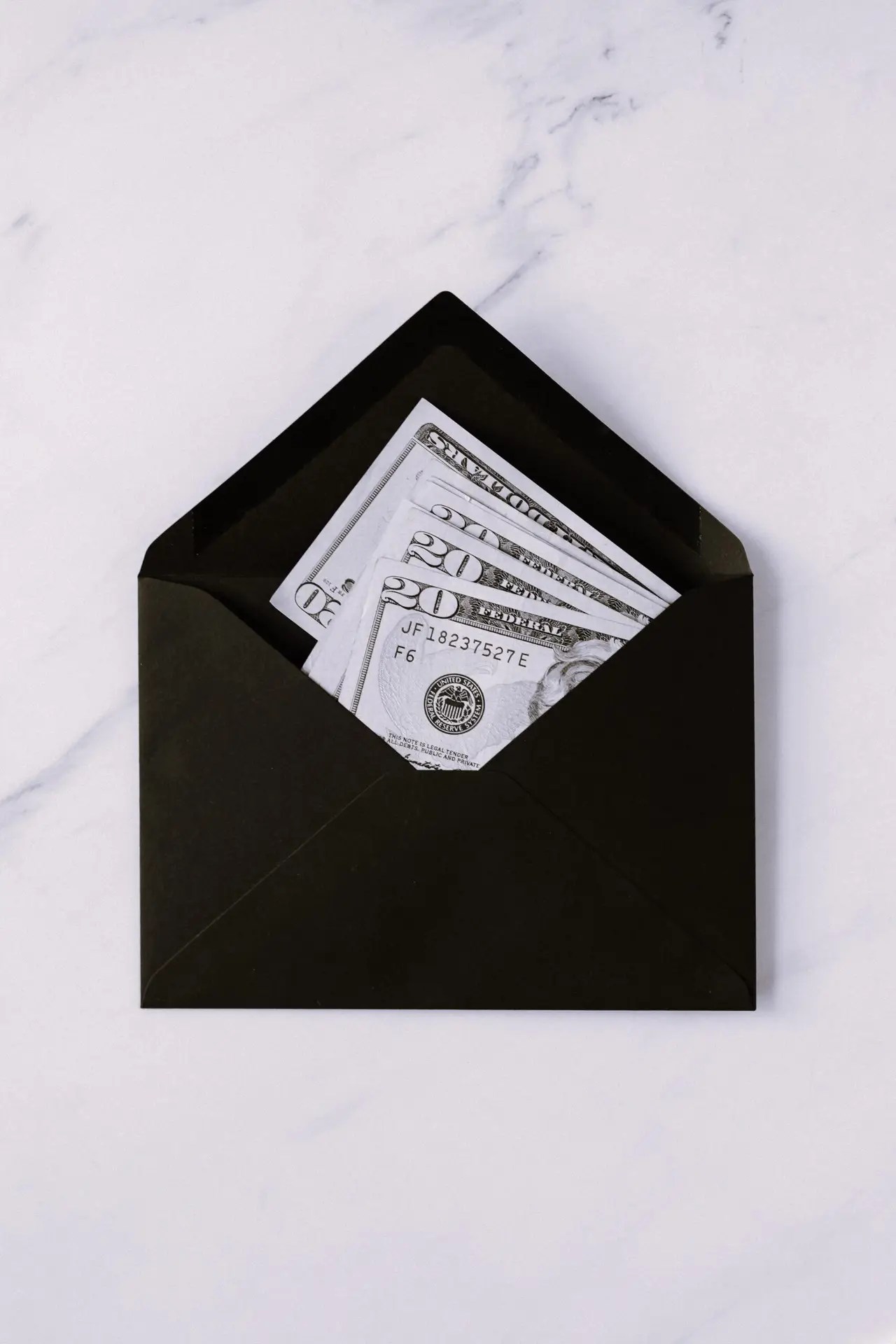 Black envelope with cash inside, representing budgeting and money management