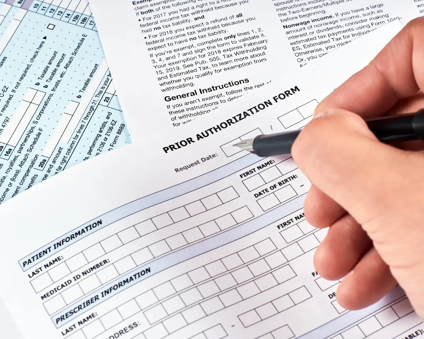 Male hand filling out Prior Authorization Processing form.
