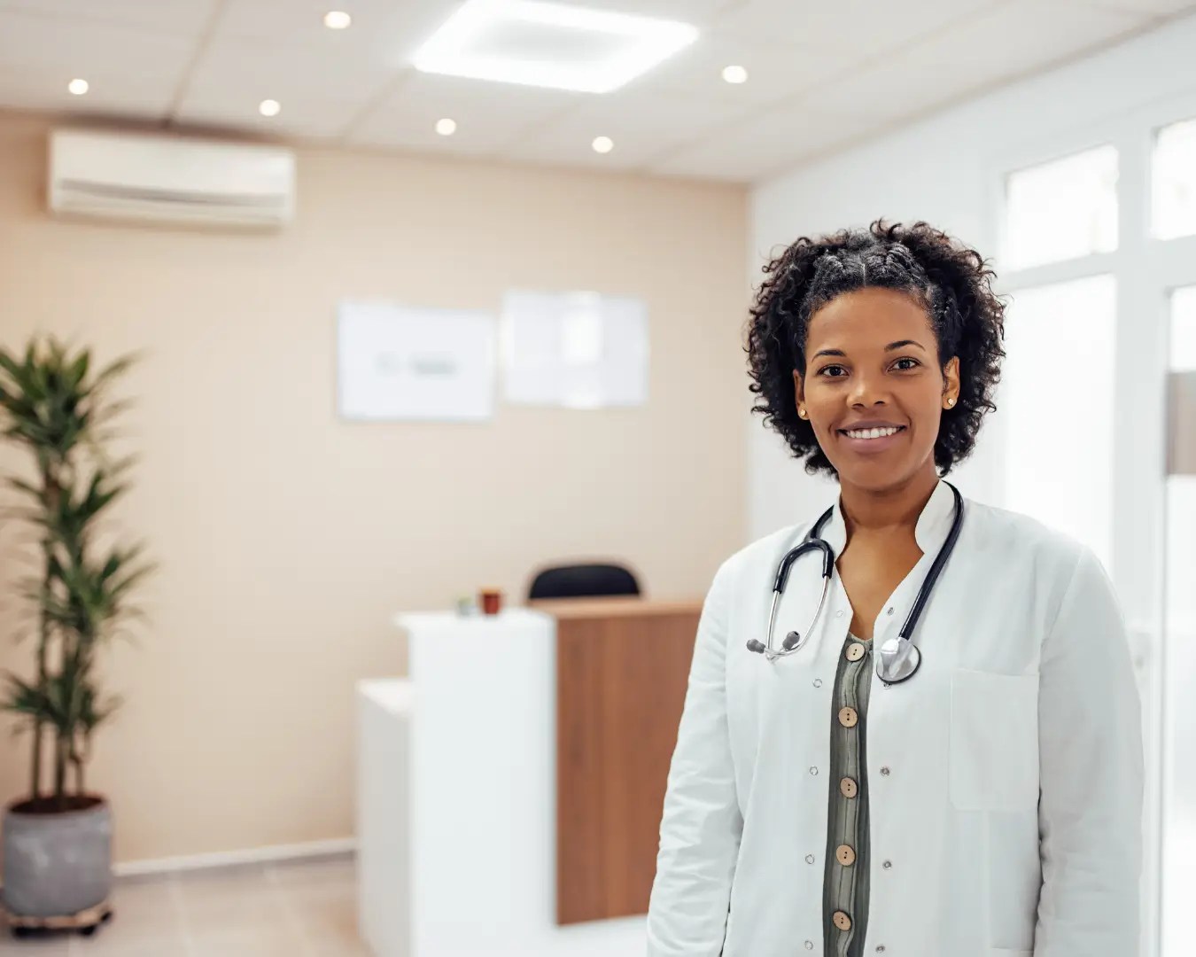 Young adult female doctor standing in lobby of new private medical practice.