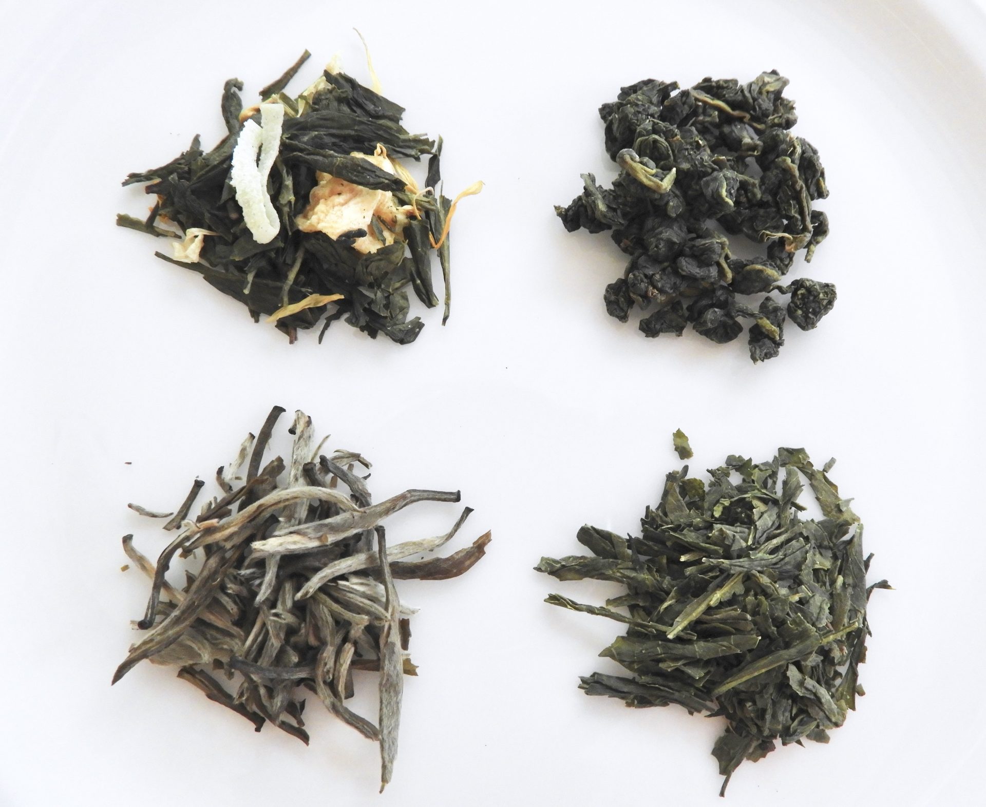 Loose leaf tea samples on white background.