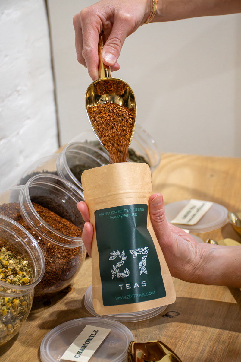 Adding rooibos to a bag for blend your own tea bar