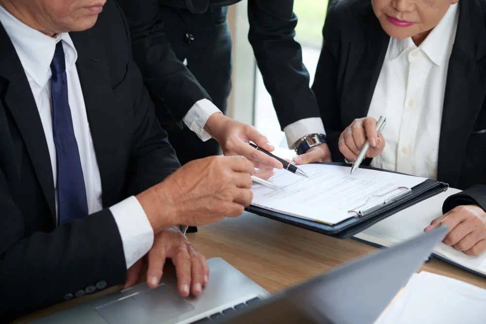 Business professionals reviewing legal trust documents for Section 351 tax-free exchange compliance and corporate restructuring strategy