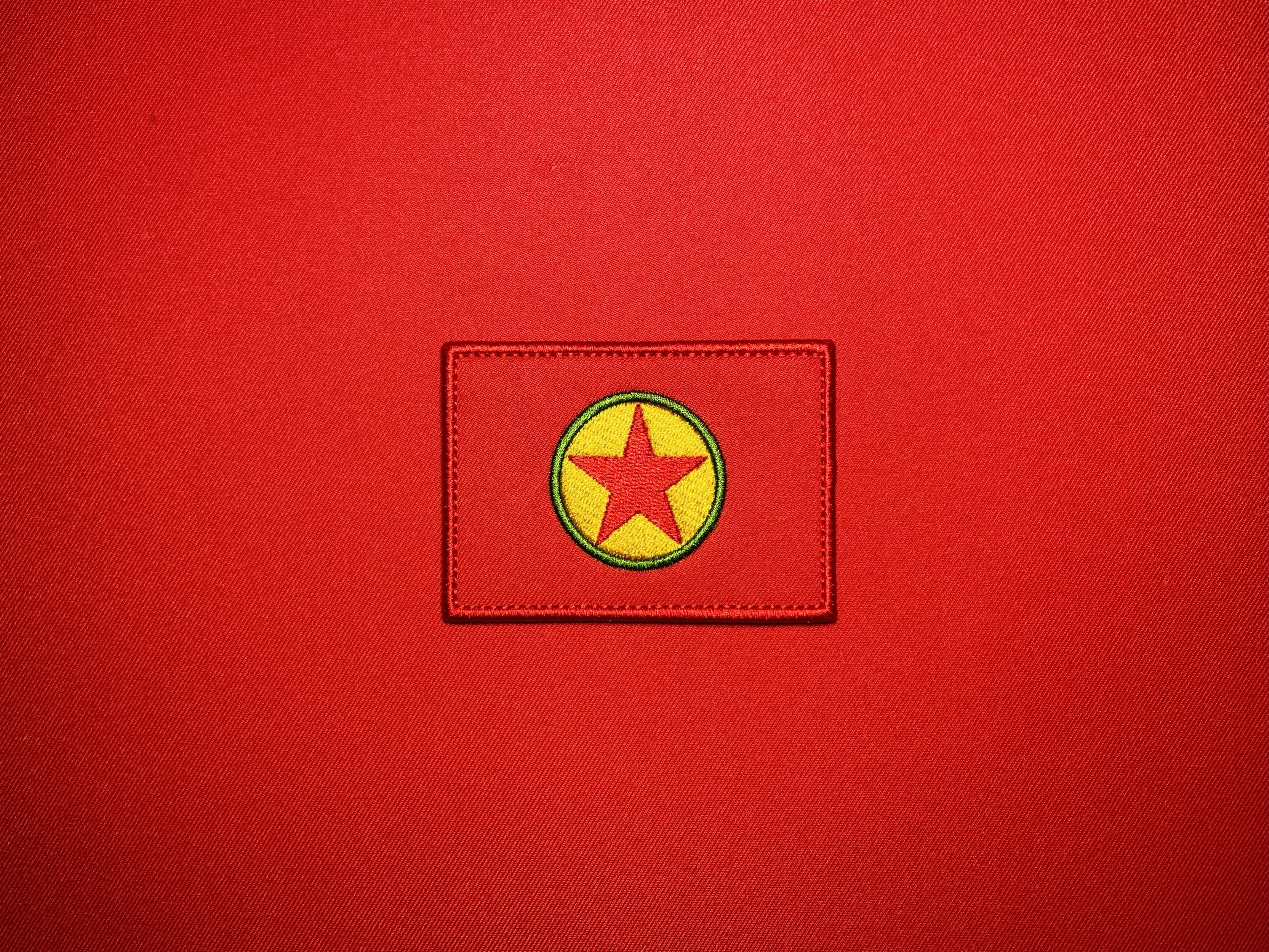 Embroidered 3.5 x 2.5 inch reproduction PKK flag patch featuring a red background with a yellow and green circular emblem and central red star.