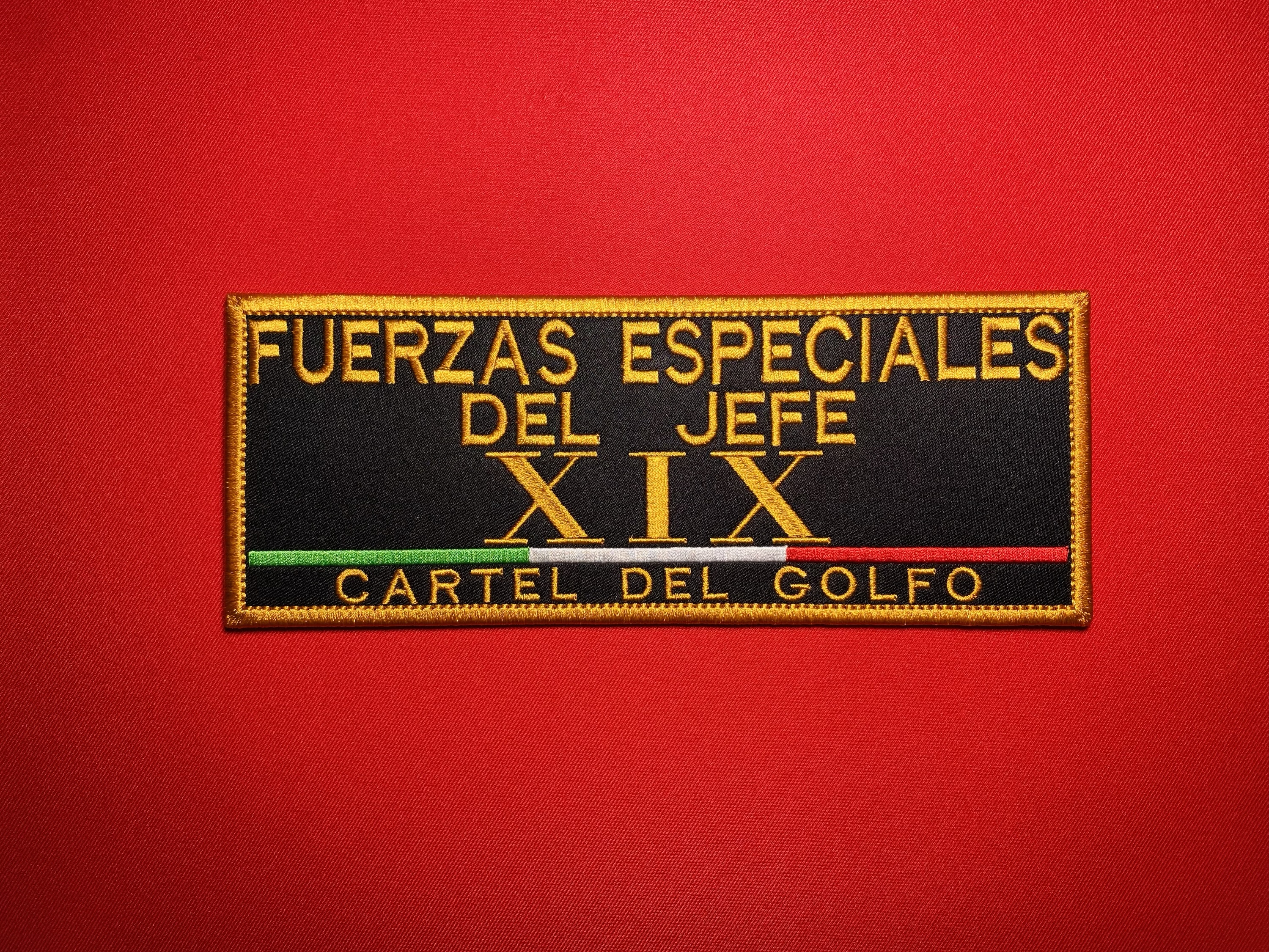 Large black and gold embroidered reproduction patch reading “Fuerzas Especiales del Jefe XIX” and “Cartel del Golfo,” featuring the Roman numeral XIX and a green, white and red tricolor stripe.