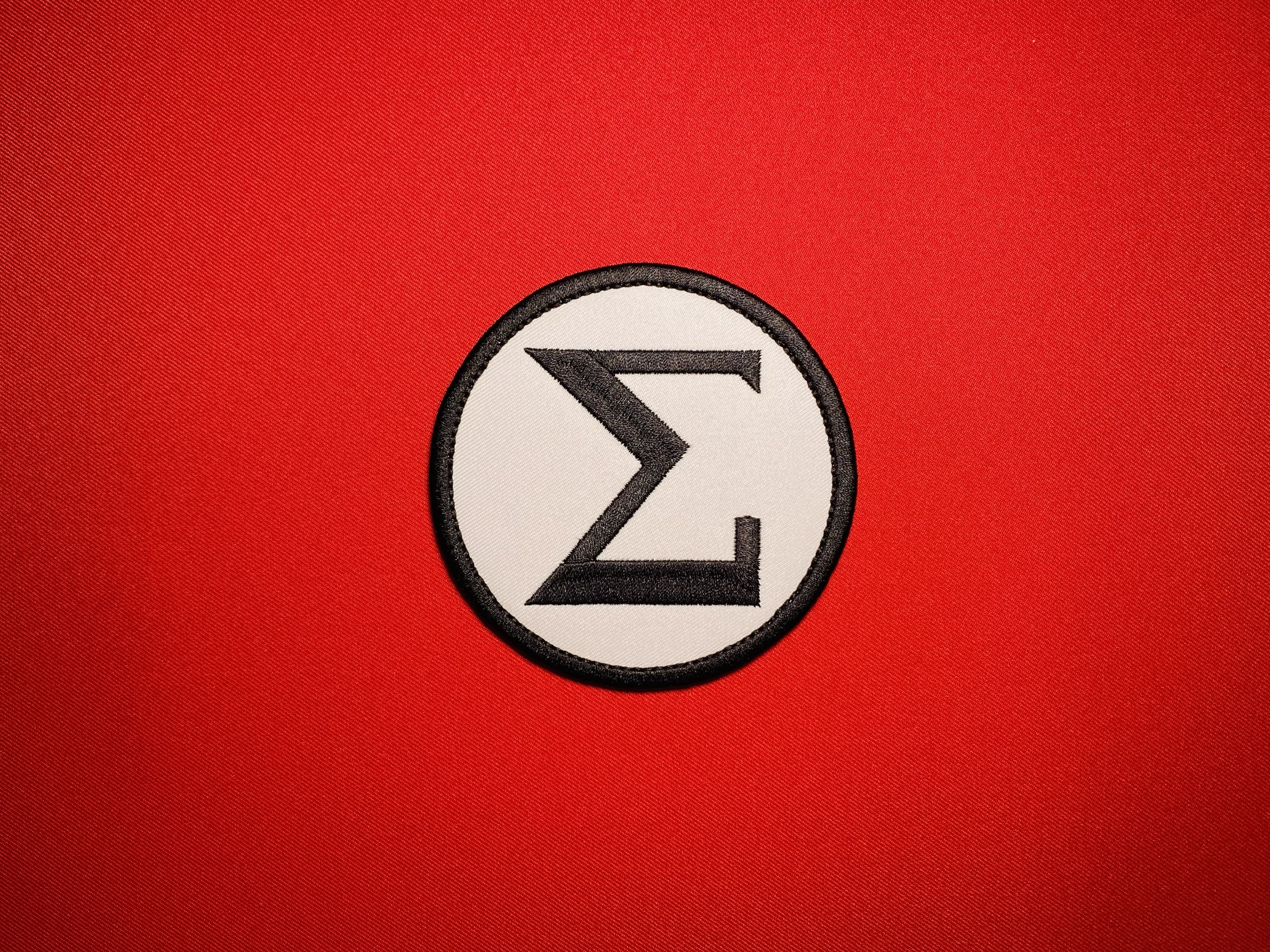 -inch reproduction AIB Sigma uniform insignia featuring a black Sigma emblem on a white circular field with a black embroidered border.