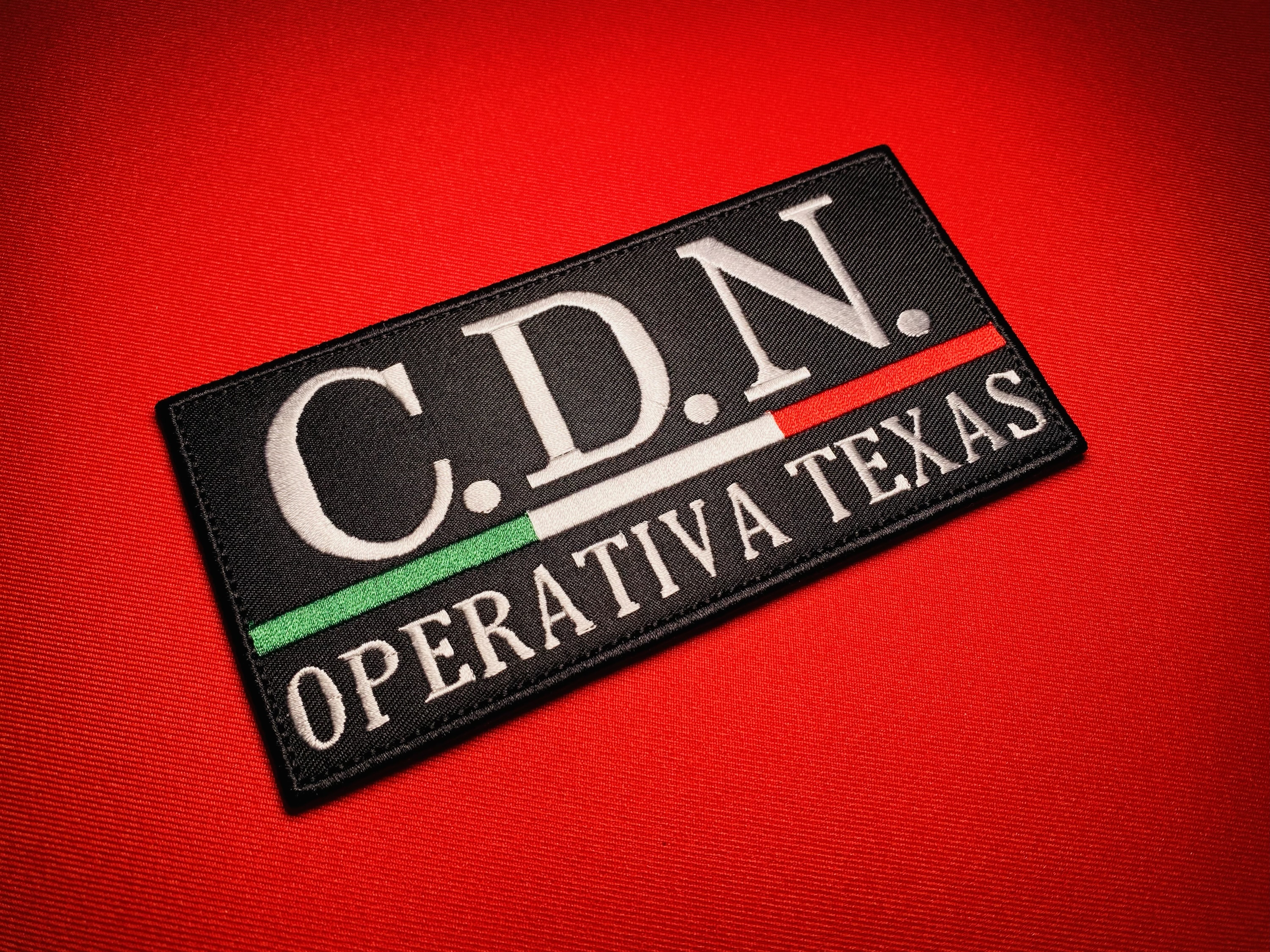 Cártel del Noreste CDN Operativa Texas embroidered tactical patch with Mexican tricolor stripe, angled close-up on red background.