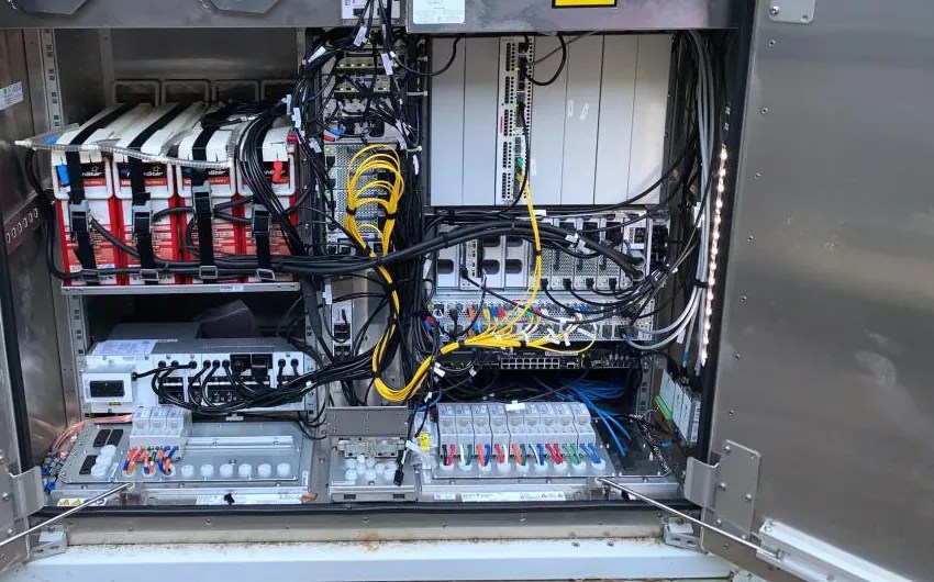 Open ground equipment cabinet with radios, power and fiber connections