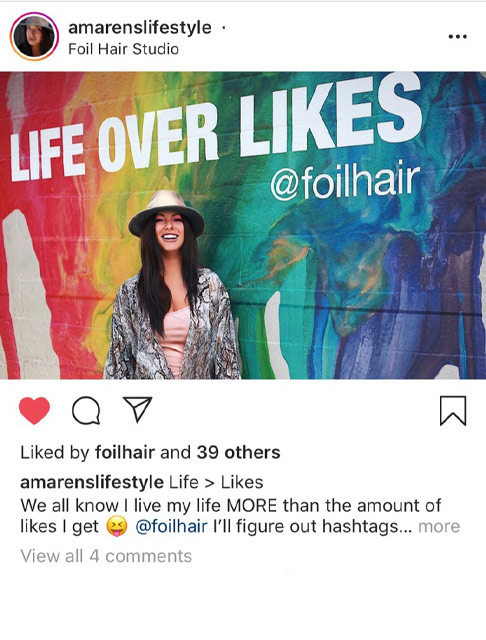 @amarenslifestyle posing in front of the LIfe over Likes outdoor wall mural