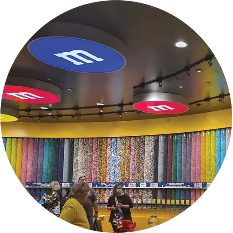 Ceiling suspended round SEG light boxes that look like M&M's at M&M store