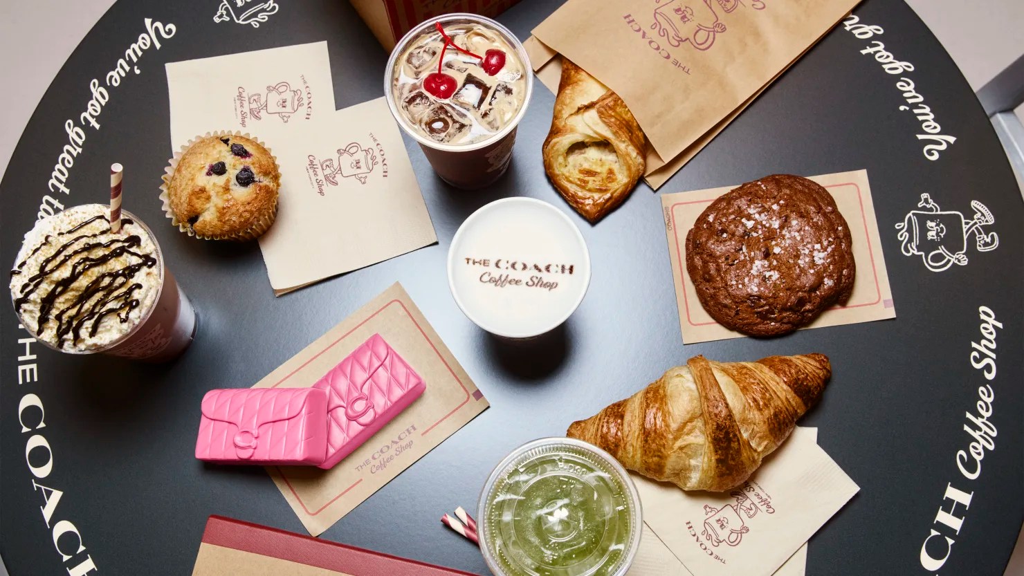 Interior of Coach coffee shop featuring branded signage, illuminated menu boards, and stylish display counters
