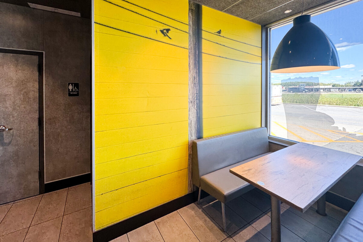 Faux brick wall covering displaying a realistic brick-pattern texture used as architectural signage and interior graphics