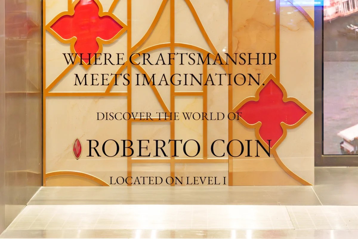 Second-surface adhesive window vinyl for Roberto Coin at Watches of Switzerland with luxury brand messaging, wayfinding text, and decorative gold pattern graphic