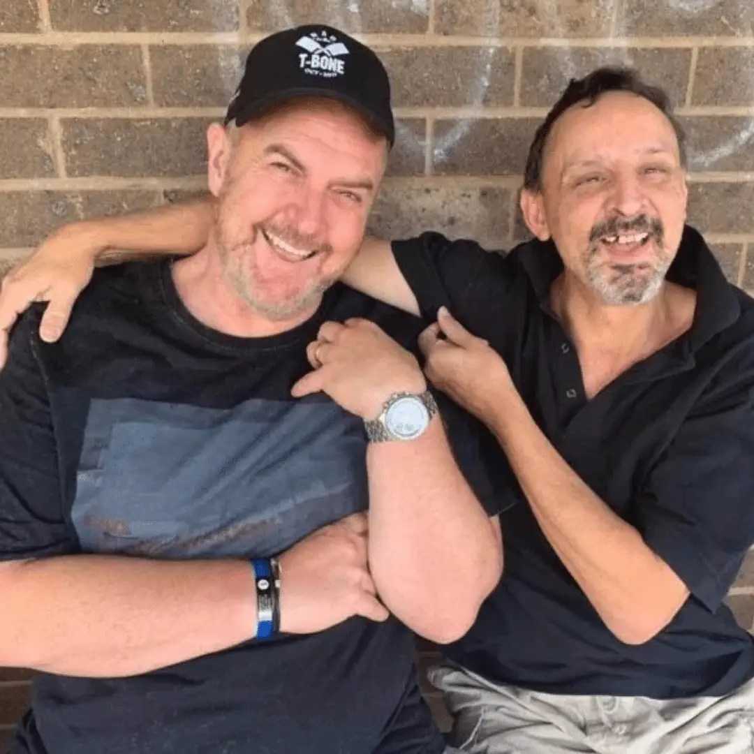 Adults enjoying an outdoor NDIS camp adventure with campfire and bushwalking