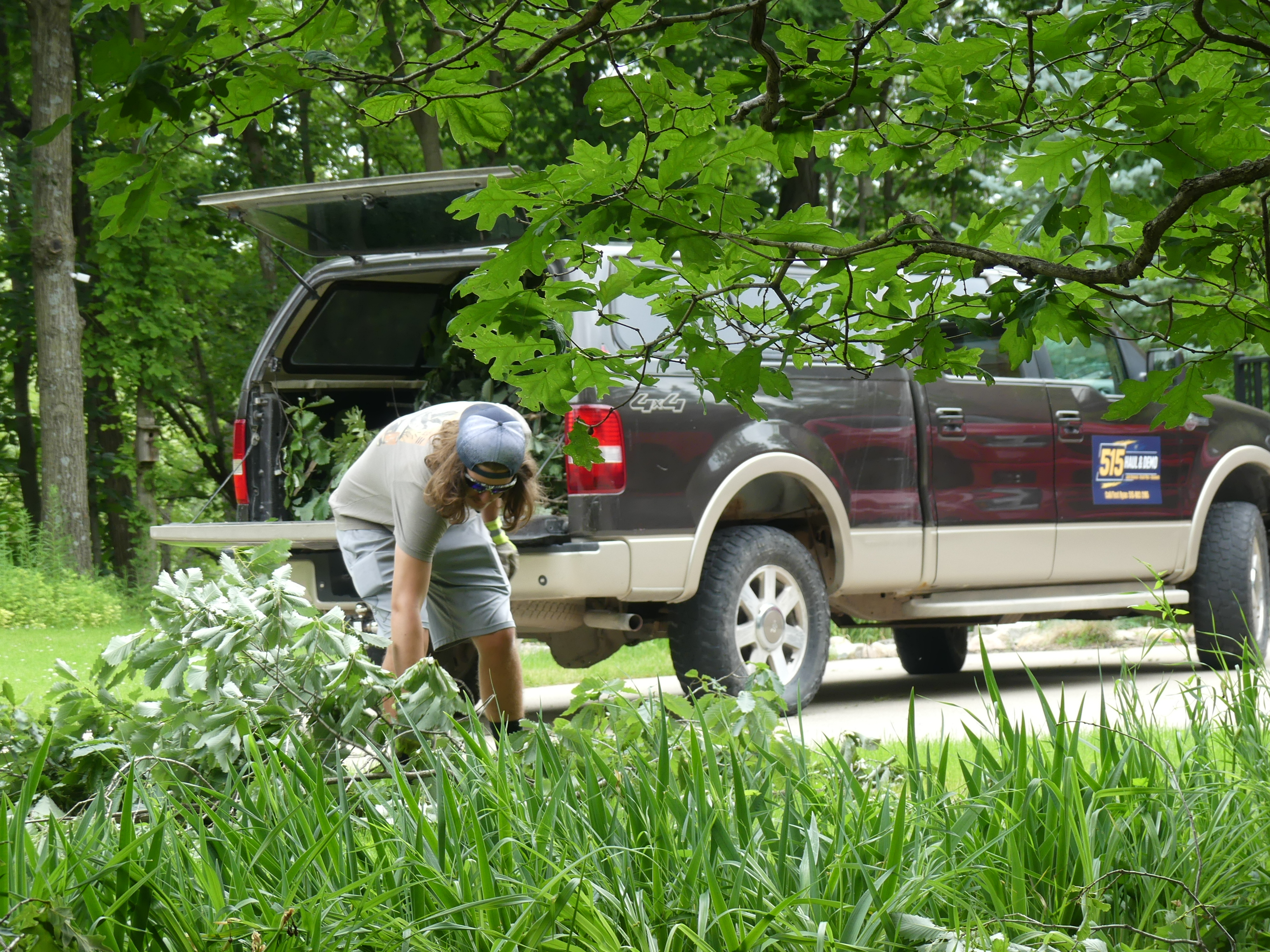 Yard with scattered brush and debris before cleanup in Central Iowa