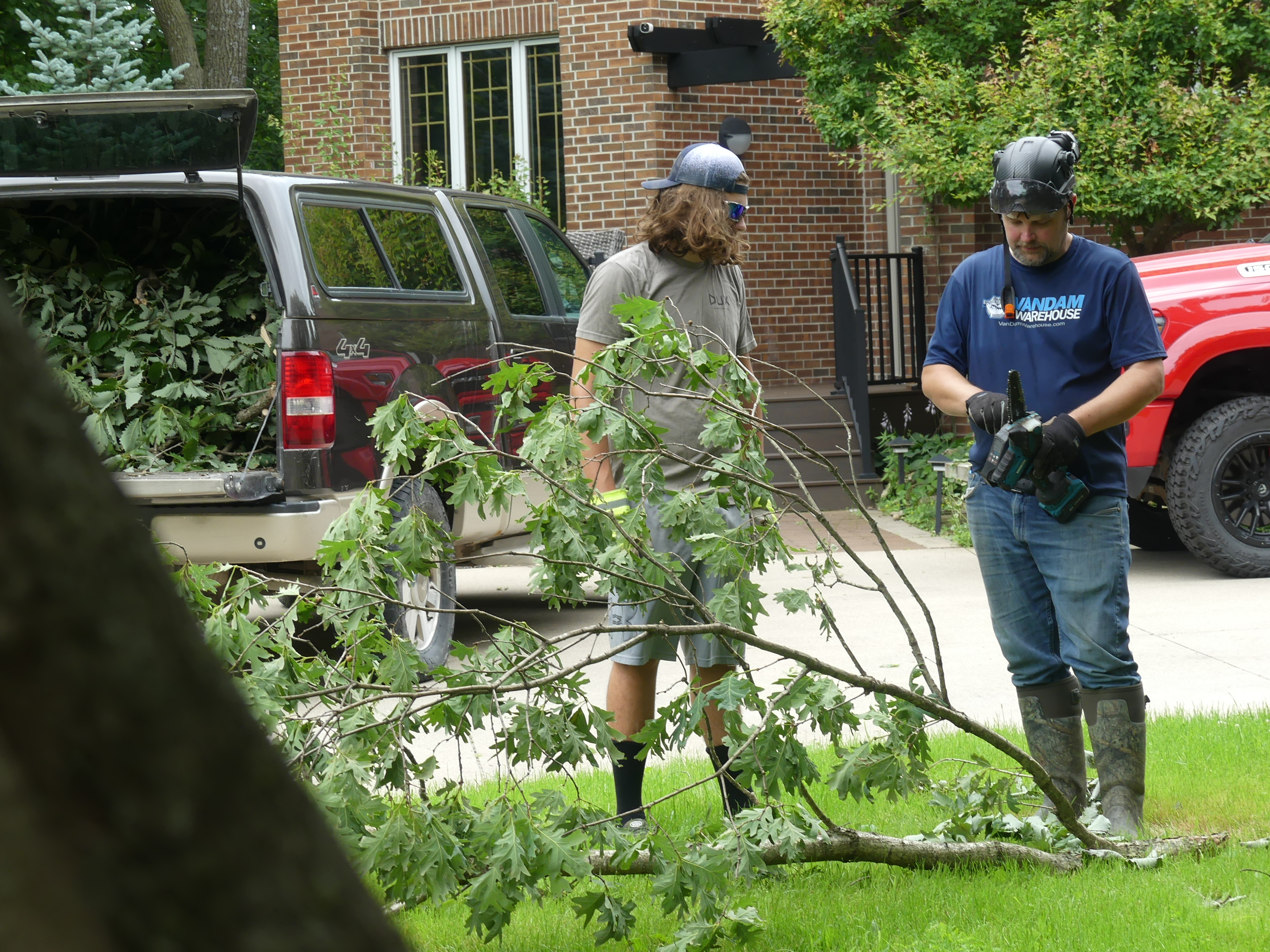 Large downed oak limb lying on a lawn as storm debris before cleanup in Central Iowa