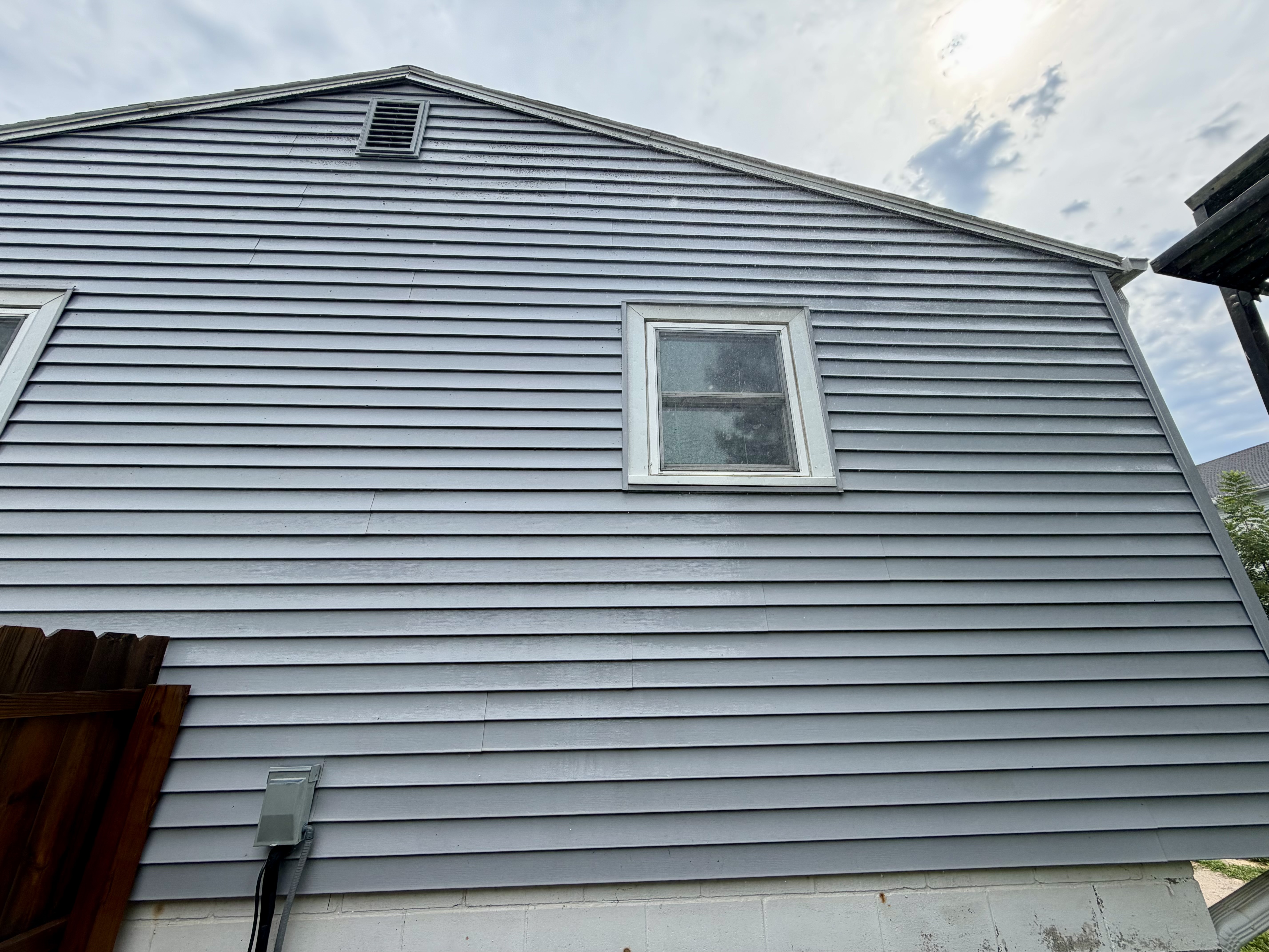 Clean house siding after pressure washing in Central Iowa
