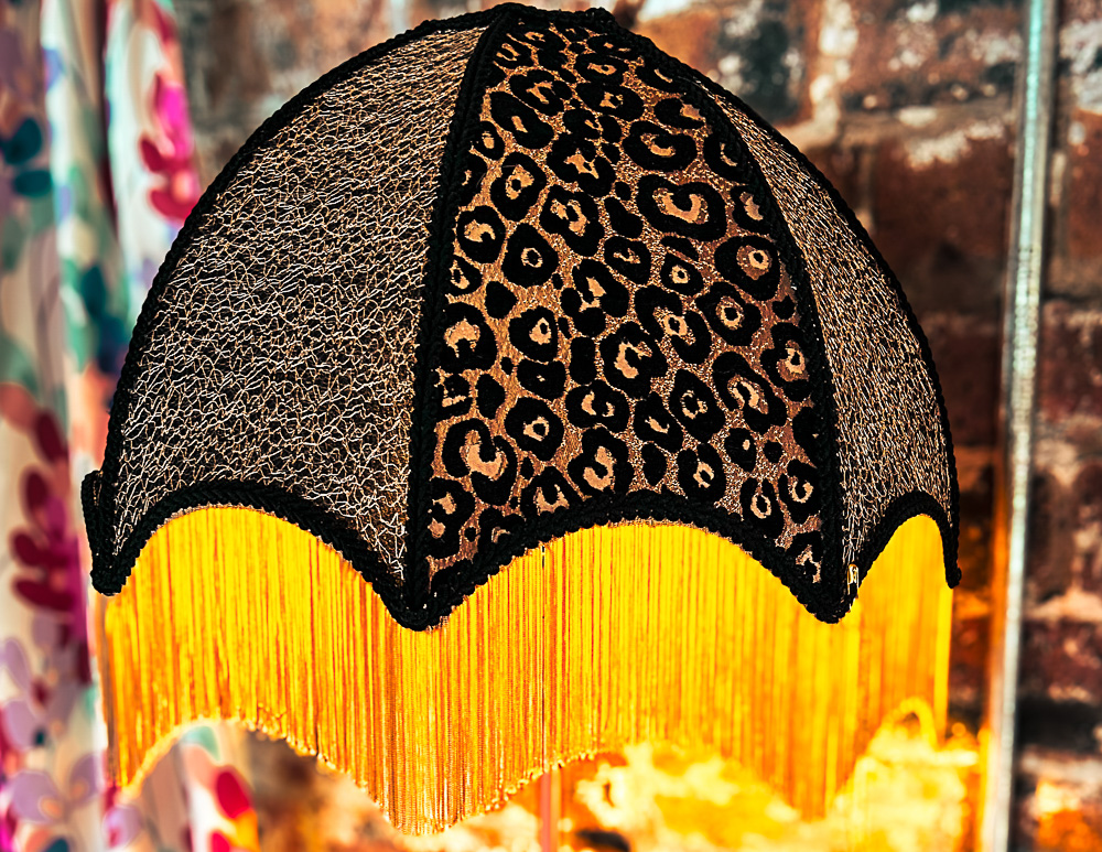 A large leopard print and black lampshade with gold trim.