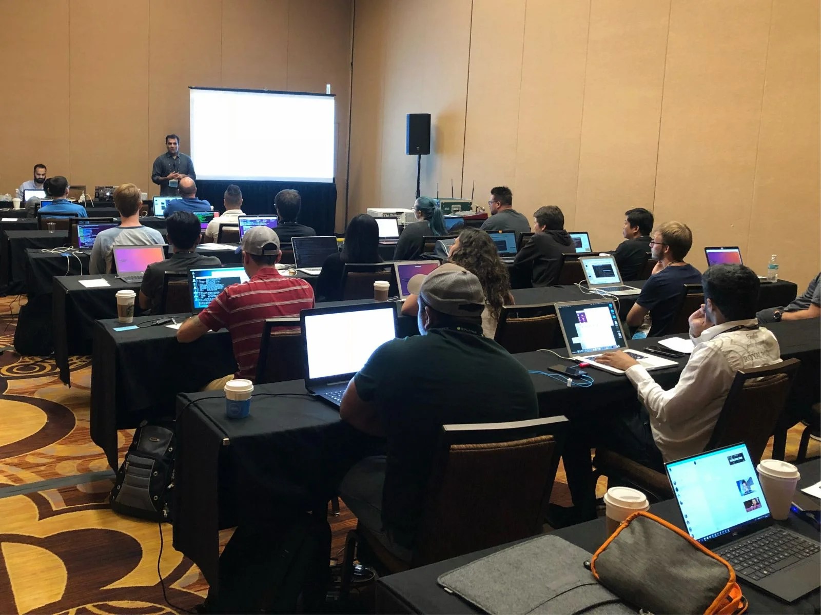 Wide view of a mobile security training session with attendees.