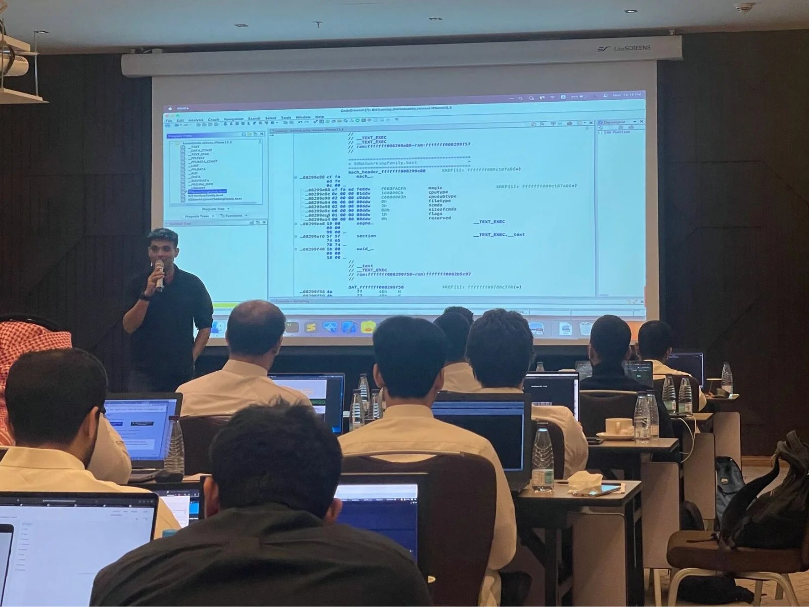 Trainer presenting on mobile security to a group using a projector.