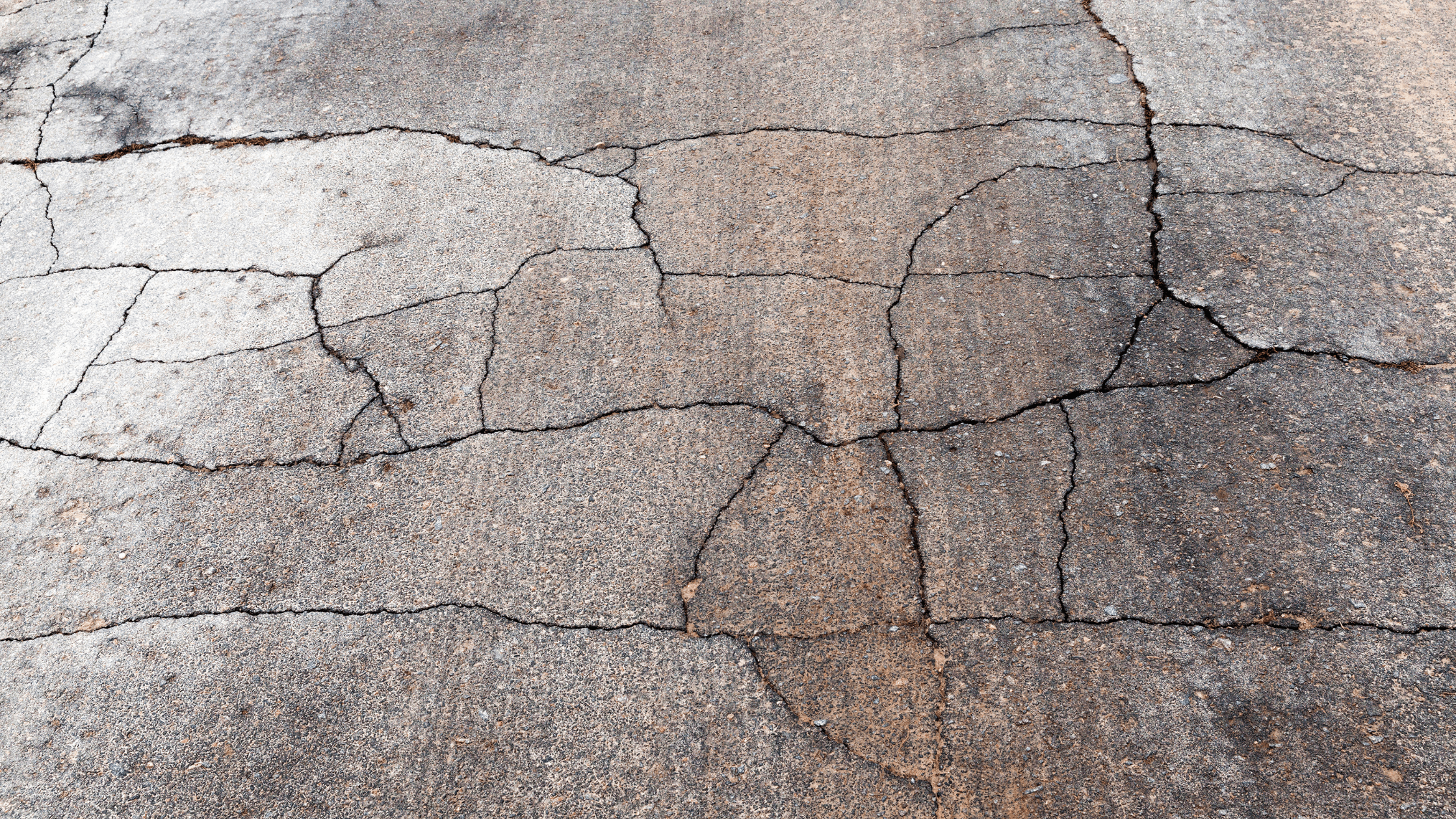 Bad Designs shown by a crumbling asphalt road