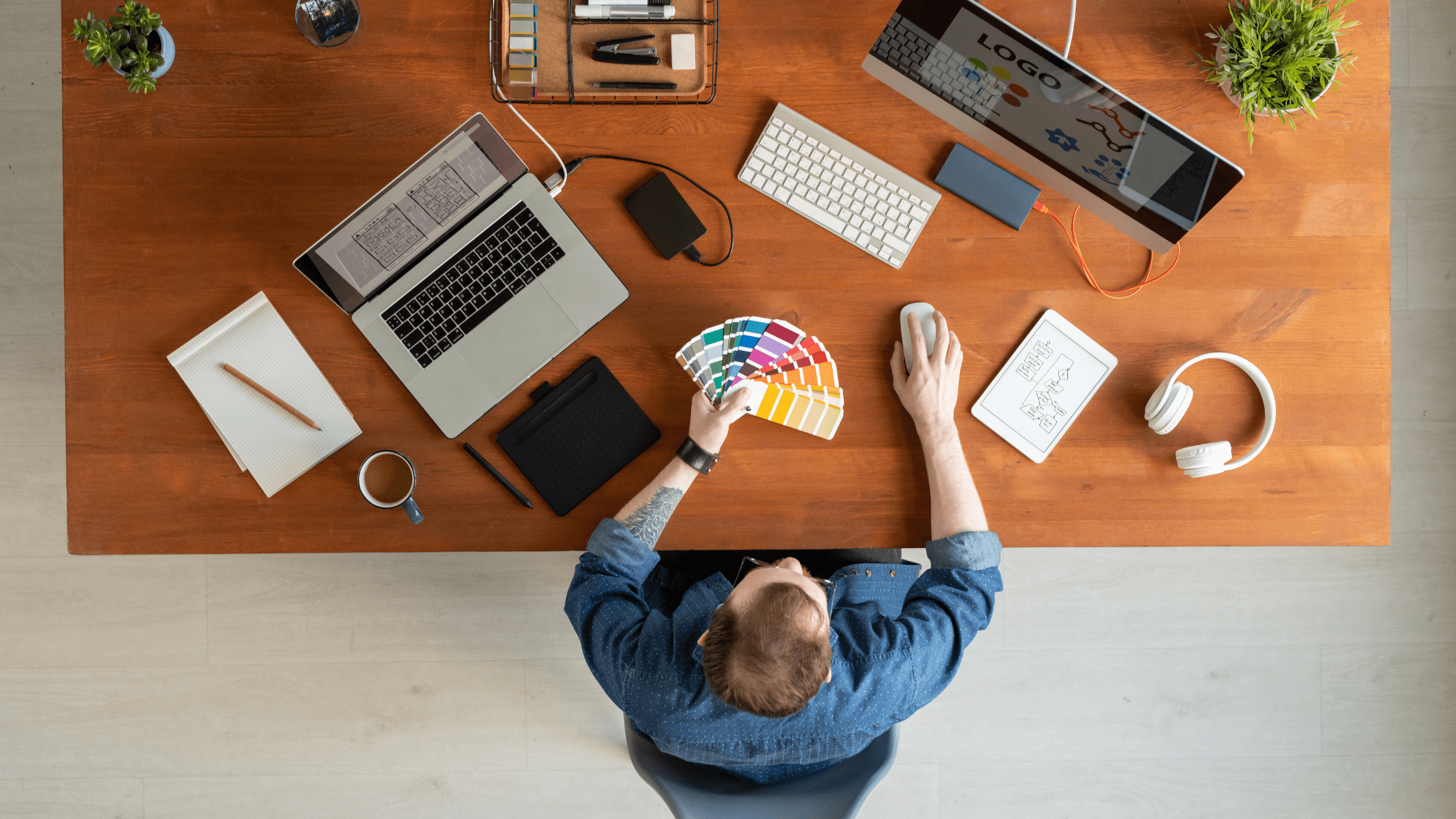 Brand Identity Design Examples in hand of young man in denim shirt choosing brand color