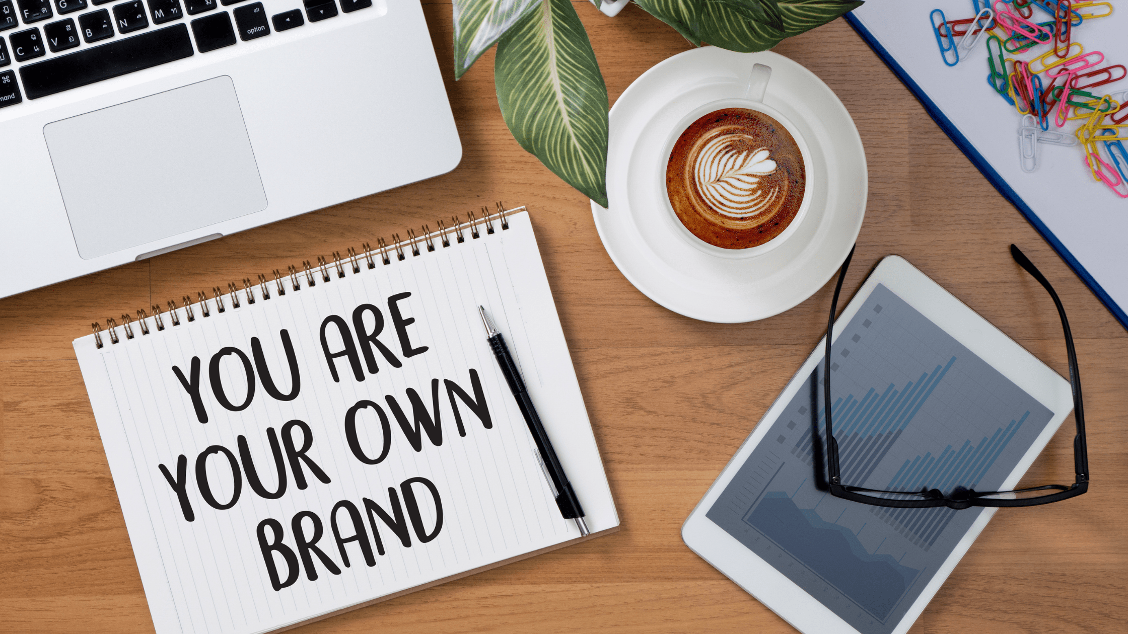 example personal branding statement shown with a notebook on a desk that says 'you are your own brand'