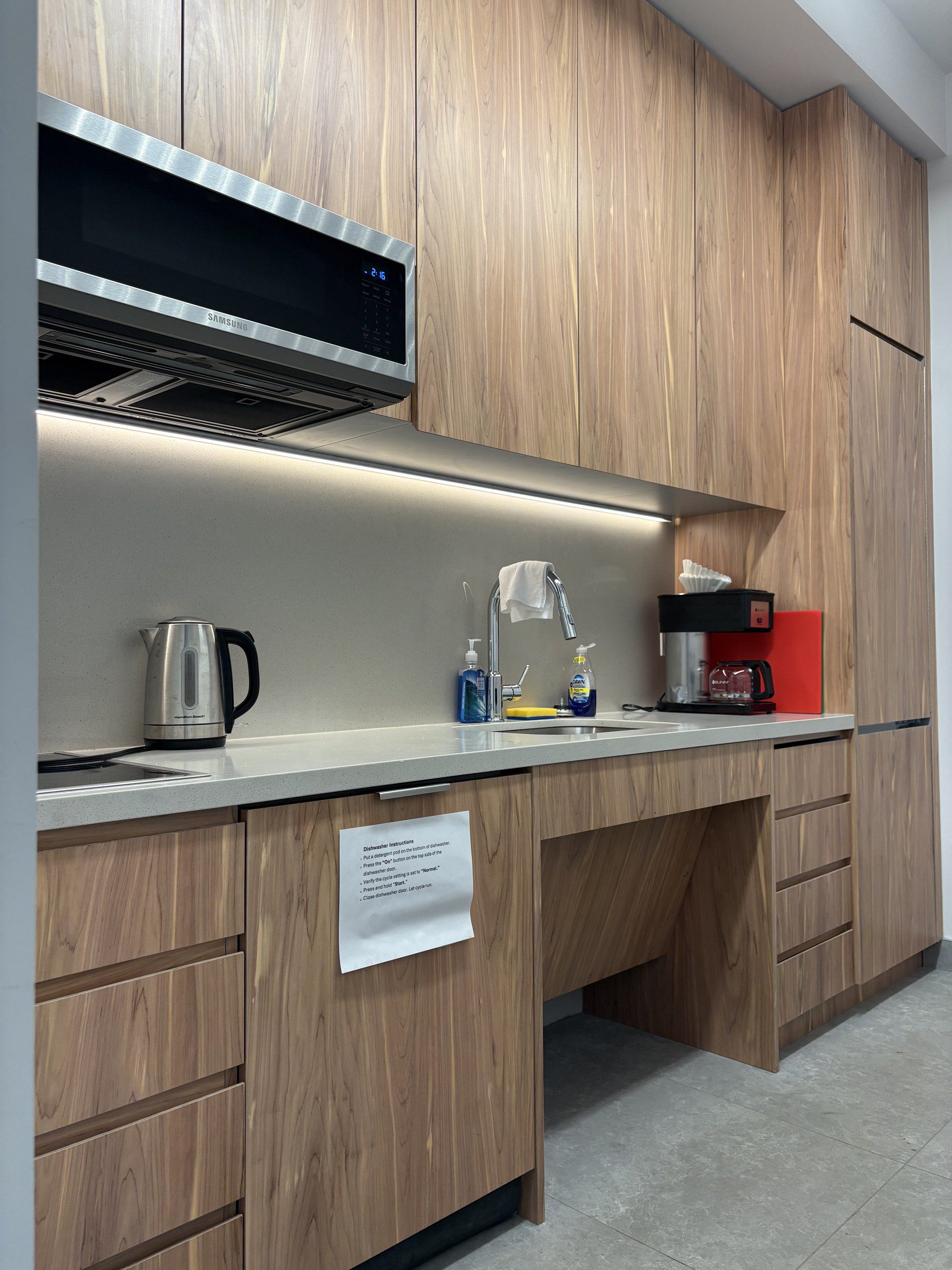 Custom wood cabinetry and staff kitchenette at The Confluence Barracks