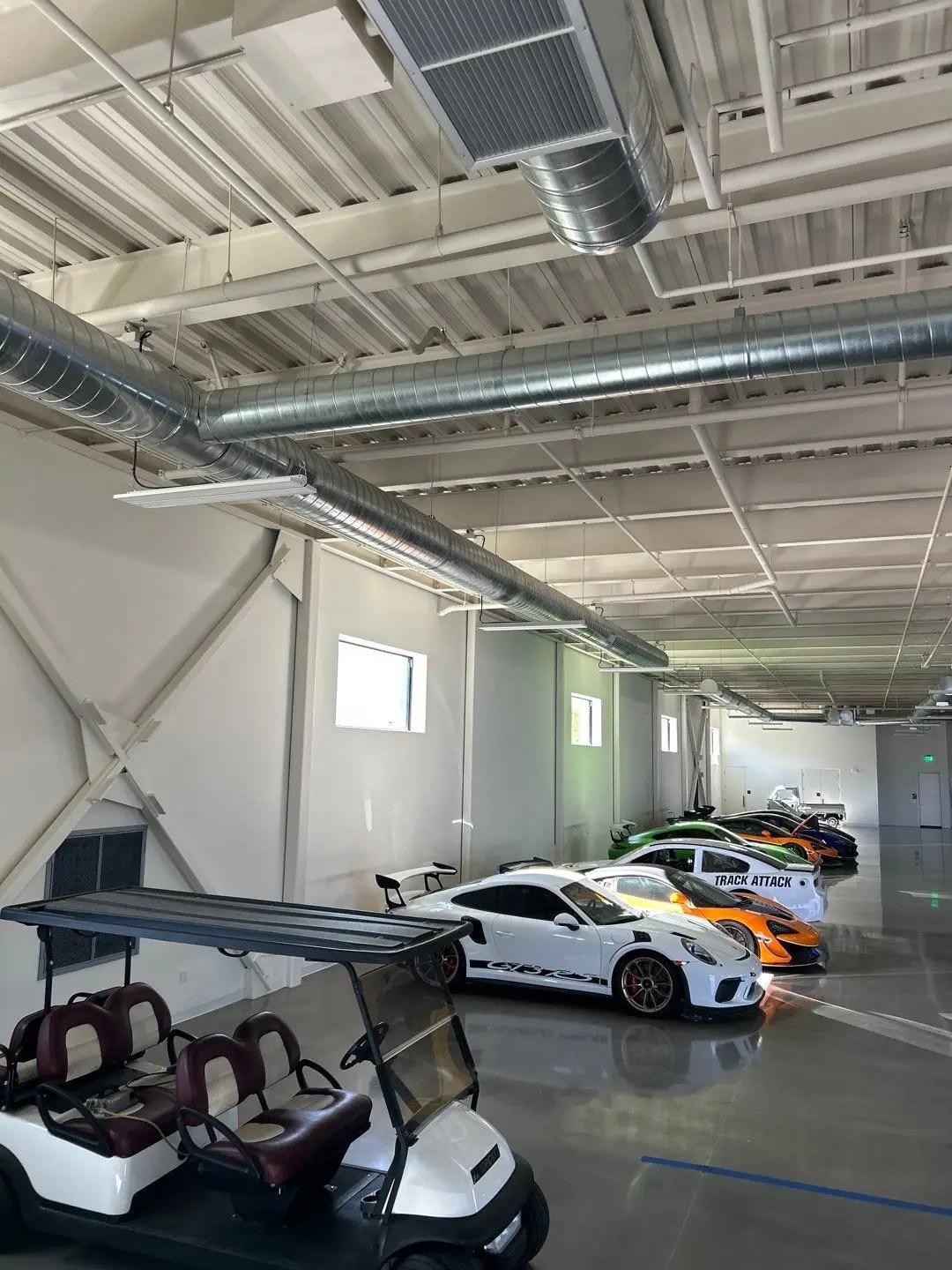 Interior photo of the car garage at Thermal Club in Thermal, CA, a racetrack, luxury experience business in Southern California. Services provided here include Air Balancing (TAB), Mechanical Acceptance Testing (MATT), and Lighting Controls Acceptance Testing (LCAT).