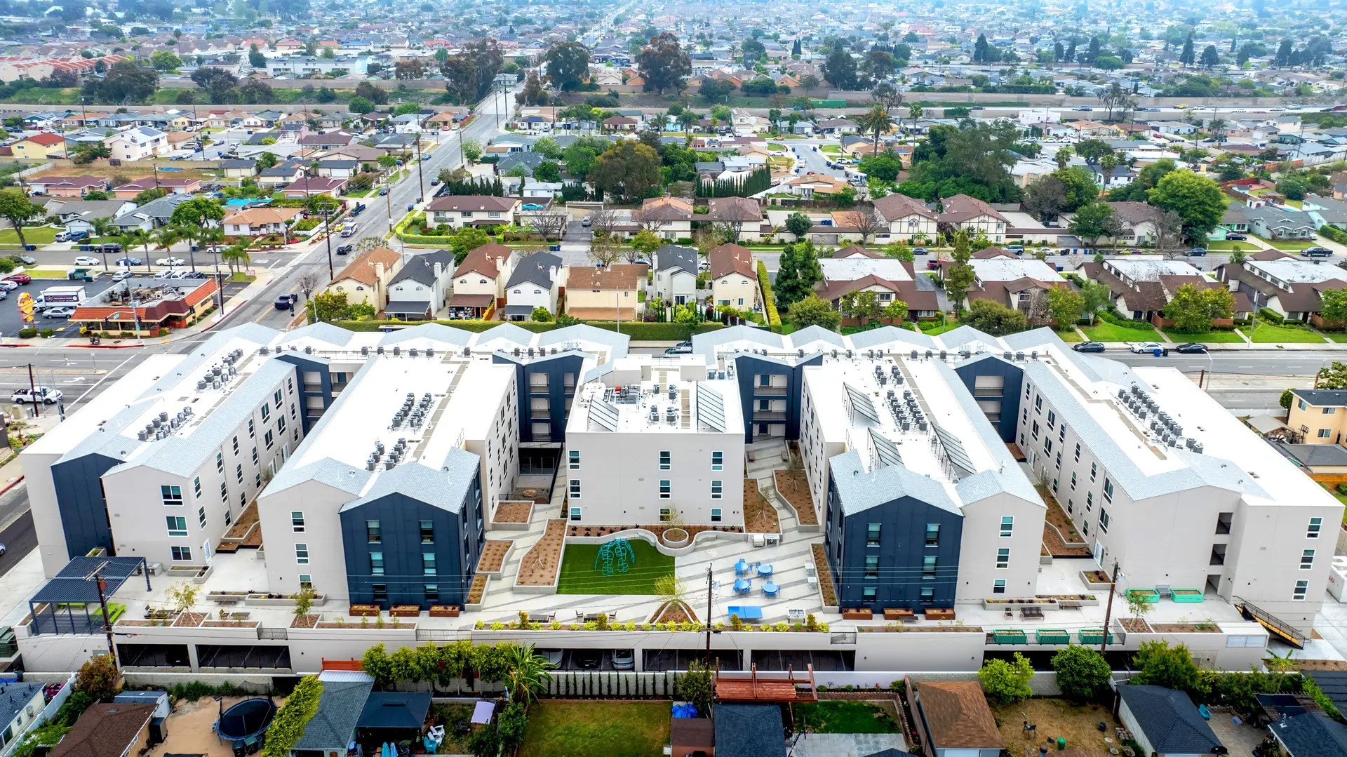 Aerial view of the West Carson Villas, a low-income supportive housing development. ECC and HERS verifications and tests for LEED Gold certification services performed. Energy Code Compliance. Home Energy Rating System. Torrance, CA, a city in Los Angeles County, Southern California.