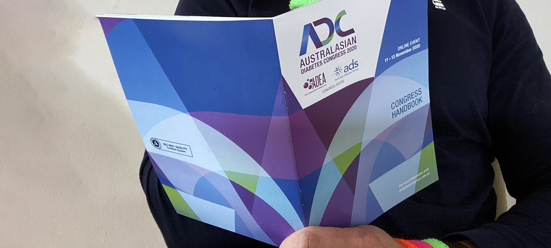 Person holding Australasian Diabetes Congress Handbook