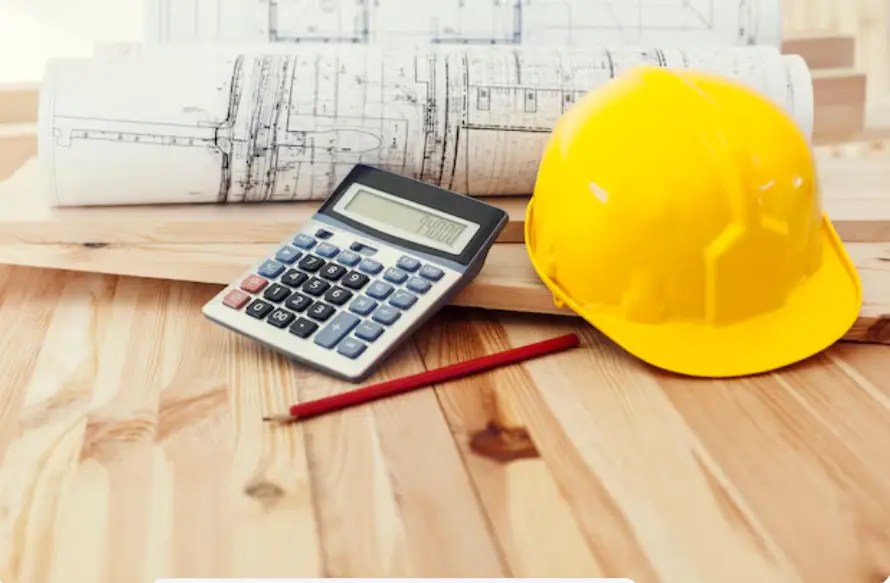 Yellow helmet with blueprints and calculator