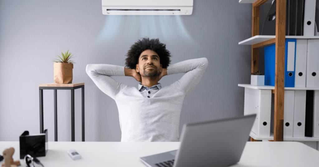 business man sitting back enjoying cool air from air conditioner