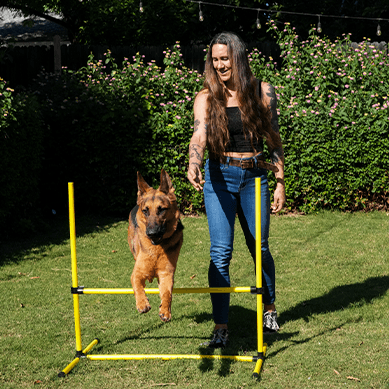 Woman training dog to jump