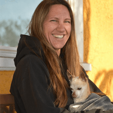 Smiling woman holding small dog