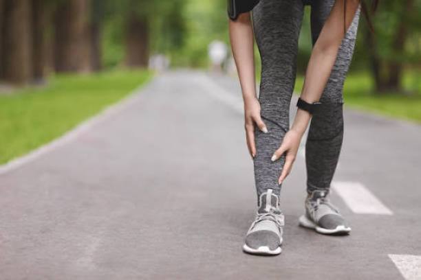 man on a road holding his shin