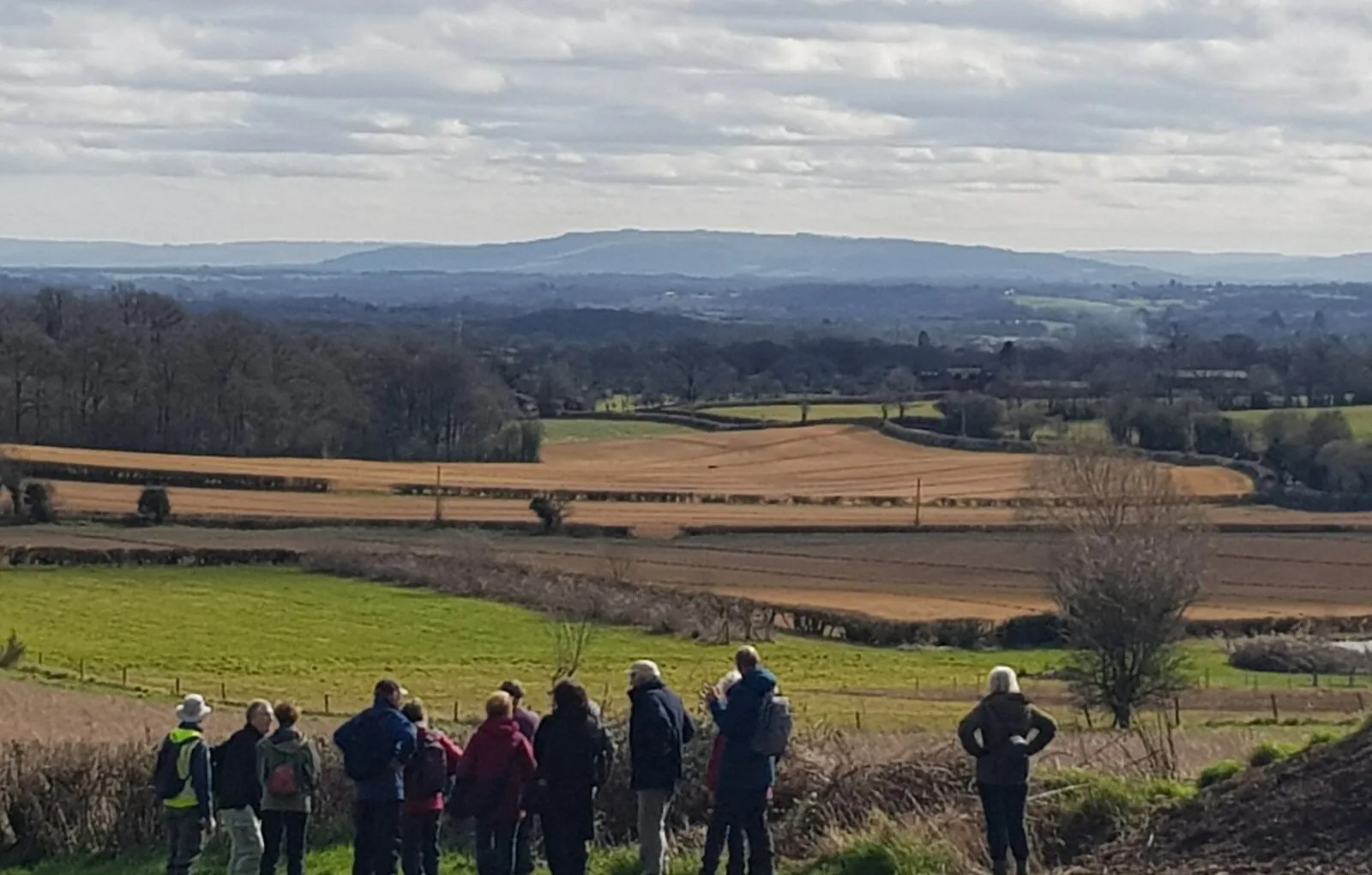 A walking group stopping to admire the view across English farmland