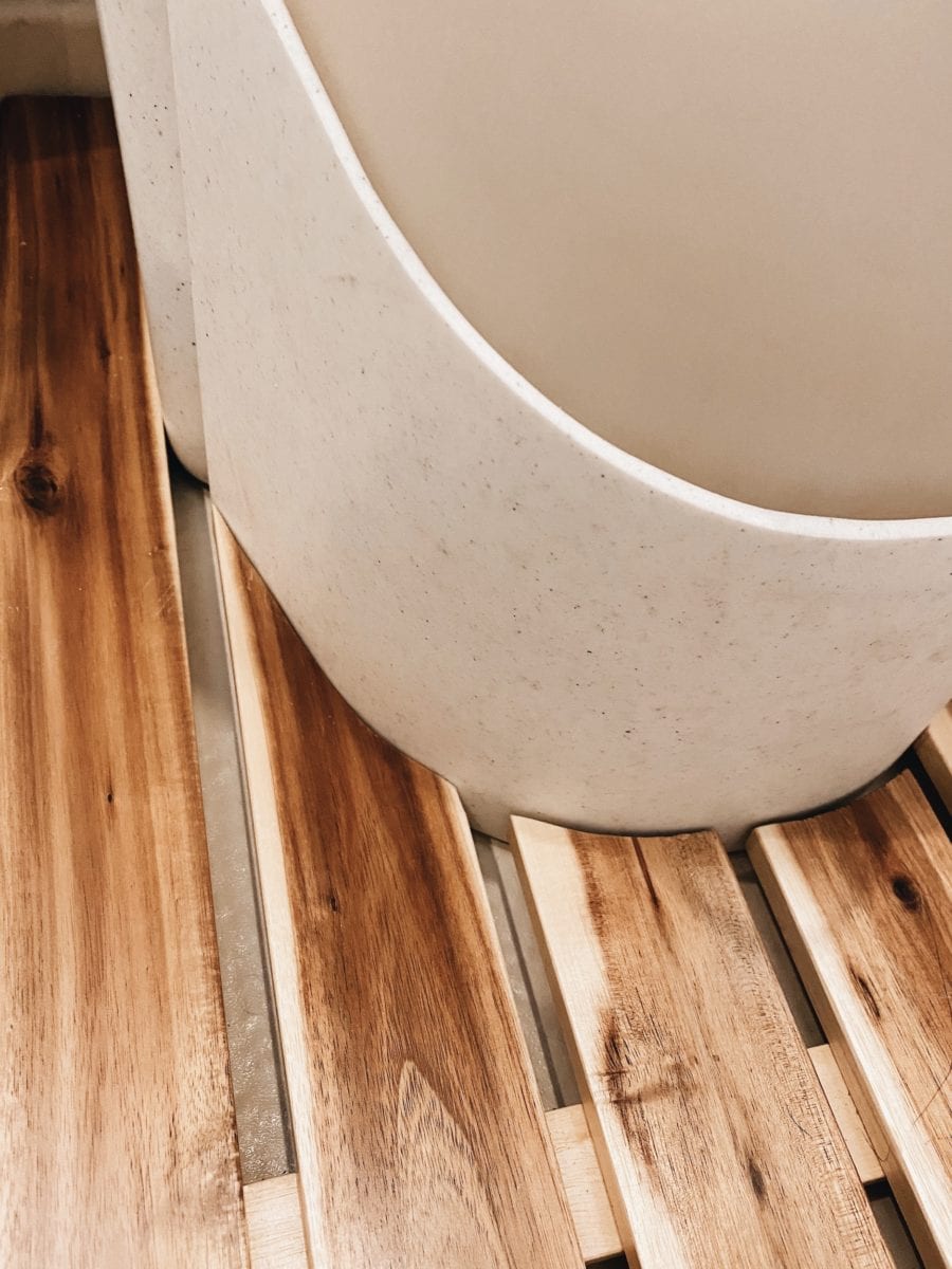 Wood shower mat around natures head toilet in a van