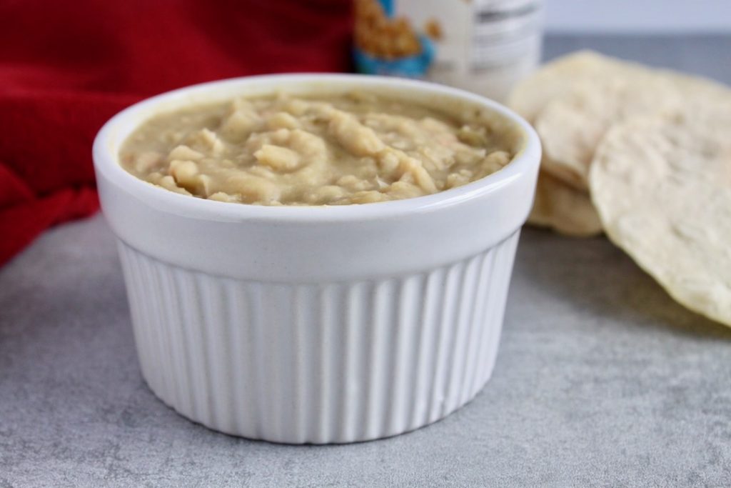 Mashed White Beans with Salsa Verde in a white ramakin with chips in the background