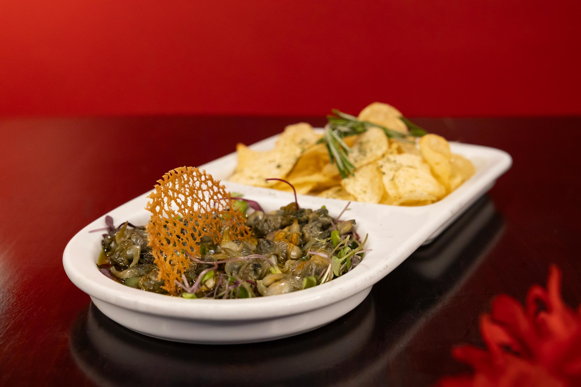 Spanish snails tapa with chips and a crisp garnish.