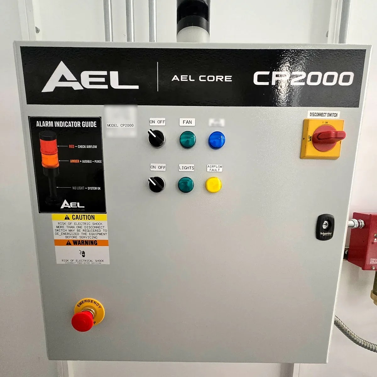Front of an AEL CORE CP2000 control panel with tower light, alarm indicator guide, fan and lighting selectors, disconnect switch and emergency stop