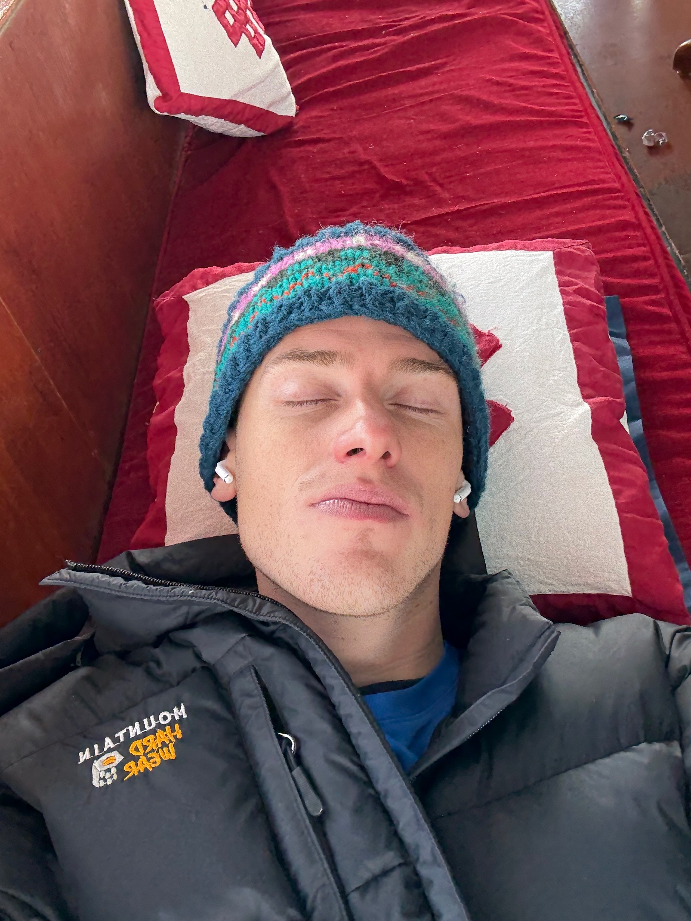 A hiker looking very unwell on a sofa.