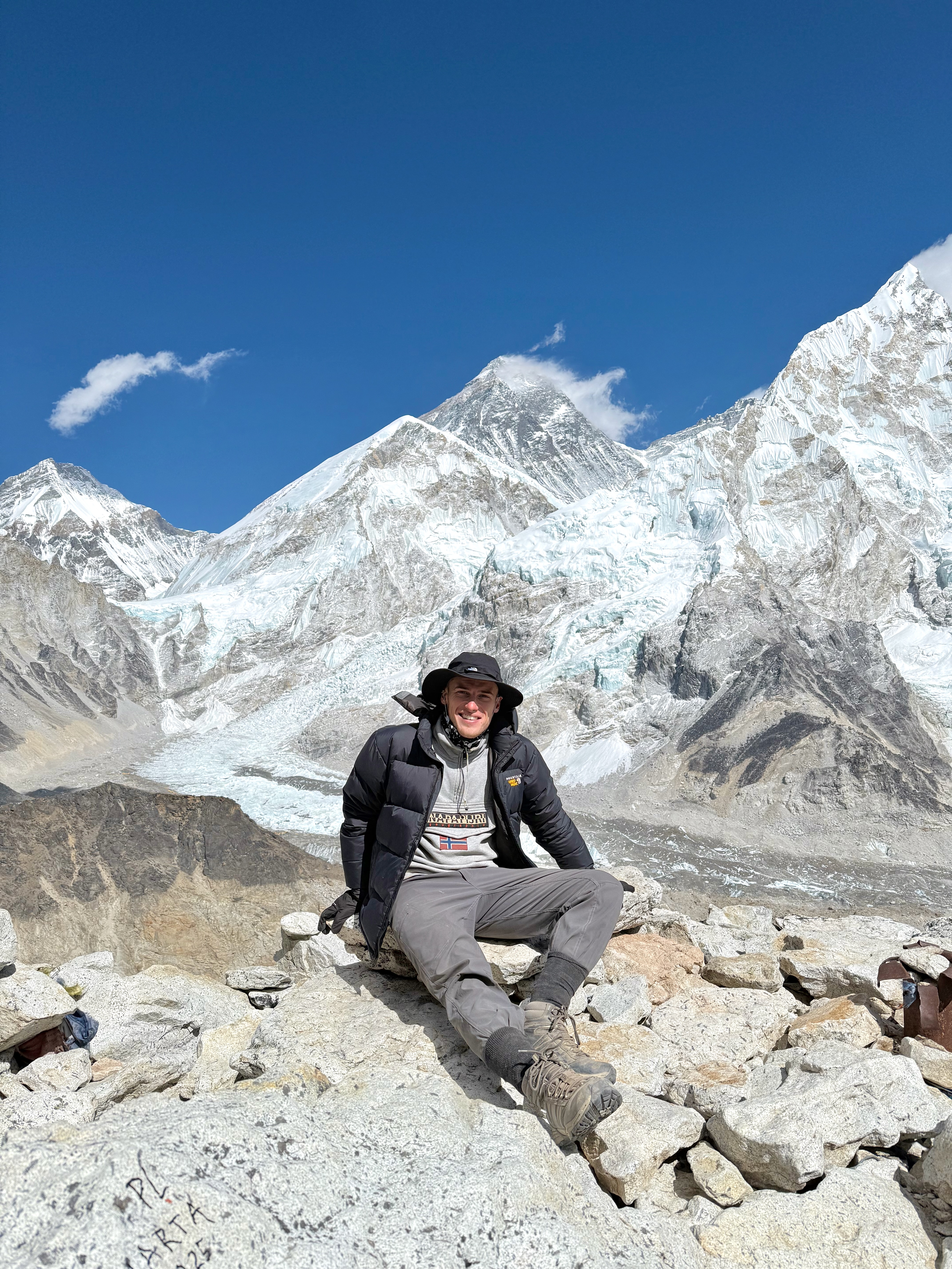 A hiker posing in front of Mount Everest