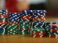 A close-up view of colorful stacked poker chips on a wooden table, perfect for casino themes.