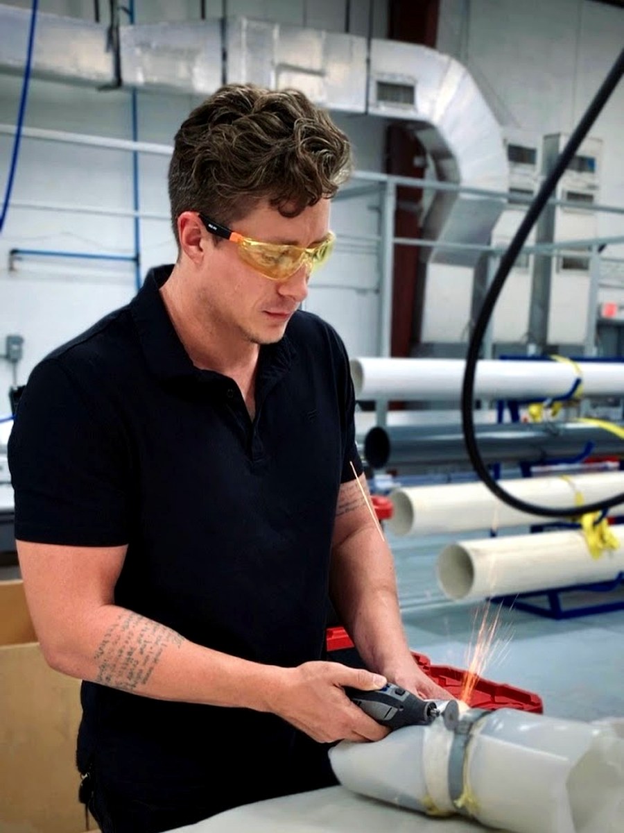 Evan Johnson grinding metal during fabrication work