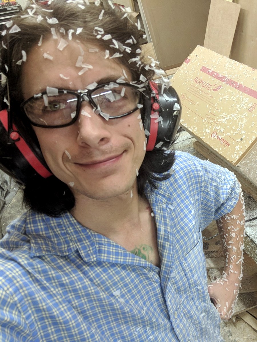 Evan Johnson in a woodshop covered in plexiglass dust